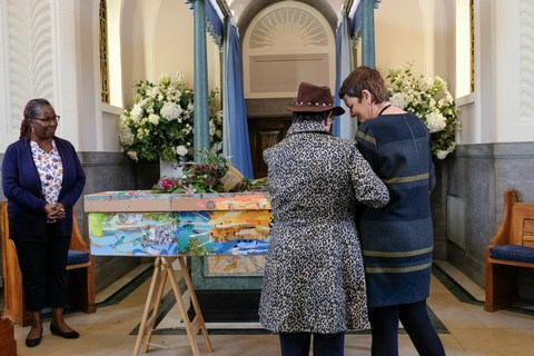 people at funeral standing near casket