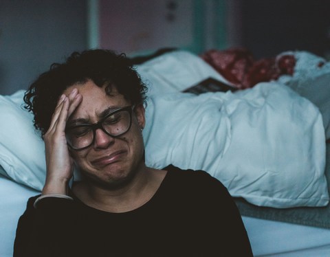 woman at work, exhausted, with hand to head crying
