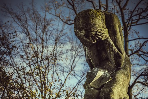 grieving woman with hands over face