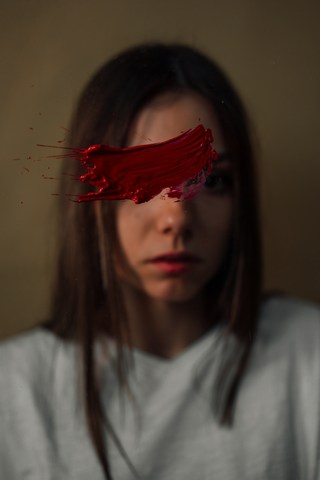 grieving woman looking at smear across mirror