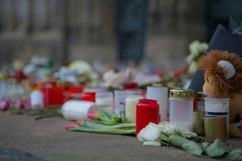 memorial flowers and candles for death on sidewalk
