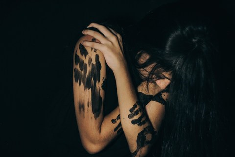 Abstract image of woman hiding her face in her arms